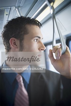 Young businessman looking through the window of a subway train