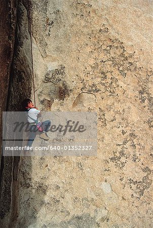 High angle view of a young boy rock climbing