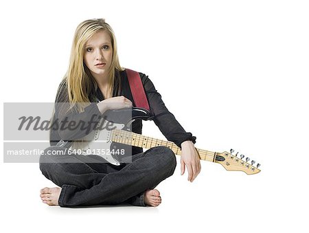Woman sitting with electric guitar