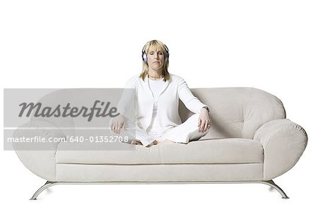 Milieu adulte femme méditant sur un canapé écouteurs