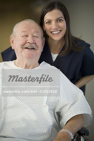Portrait of a female nurse helping a male patient in a wheel chair