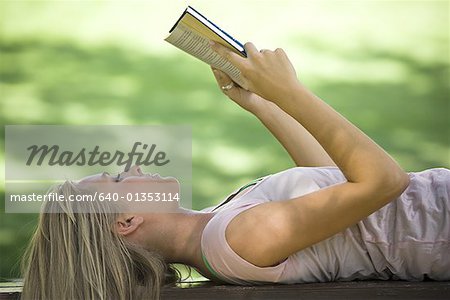 Close-up of a young woman reading a book in a park