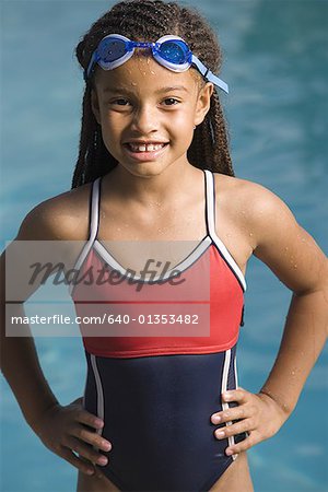 Portrait d'une jeune fille debout dans une piscine et souriant
