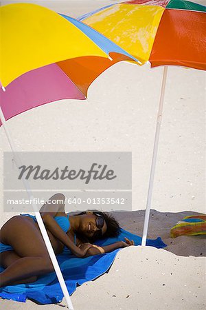 Erhöhte Ansicht einer jungen Frau, die am Strand liegen