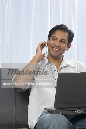 Man using a laptop and wearing a headset
