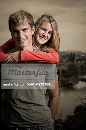 Portrait of a young man carrying a young woman piggyback