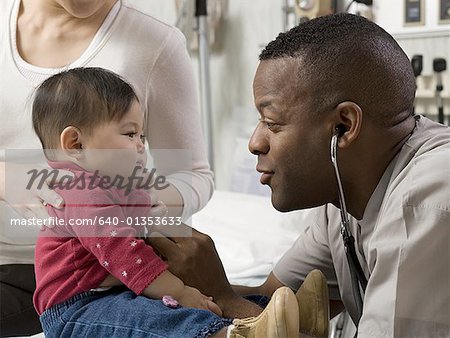 Profile of a male doctor examining a baby