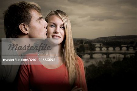 Profile of a young man kissing a teenage girl's cheek