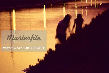 Silhouetten von zwei Menschen auf einer Sandbank