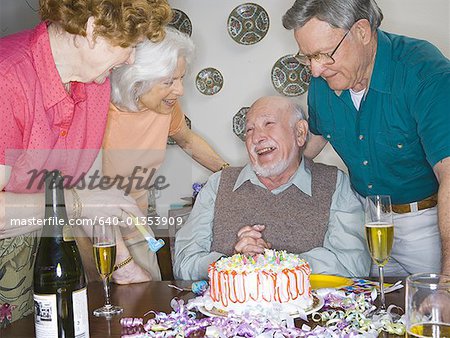 Deux couples seniors souriant lors d'une fête d'anniversaire