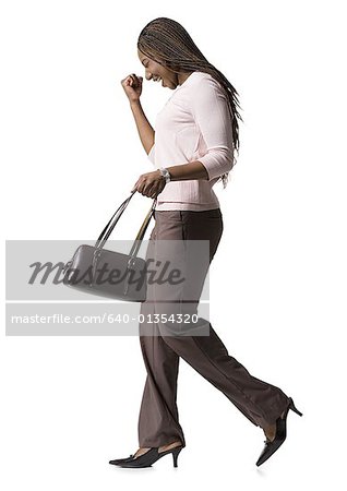 Profil einer jungen Frau zu Fuß mit einer Handtasche
