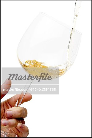 Close-up of white wine pouring into a wineglass