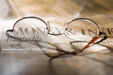 Close-up of eyeglasses lying on a newspaper