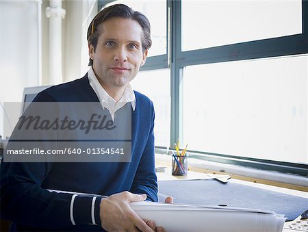 Portrait d'un architecte holding blueprints