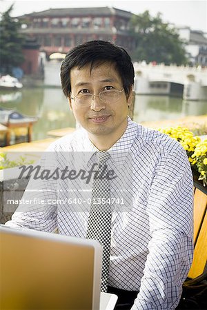Homme avec ordinateur portable en complet-veston en plein air