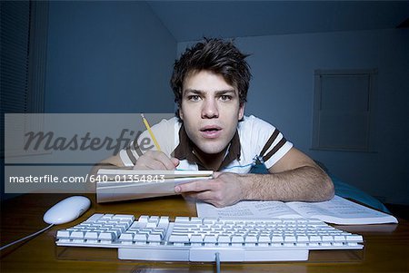 Homme au clavier avec crayon et papier, prise de notes