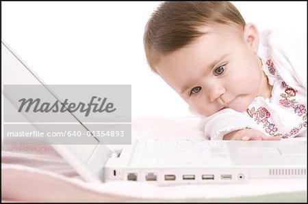 Close-up of a boy reaching for a laptop