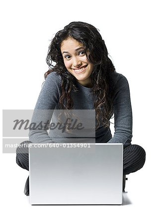 Woman sitting cross legged with laptop smiling