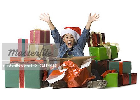 Portrait of a boy sitting with Christmas presents around him