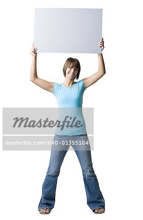 Portrait of a teenage girl holding a blank sign