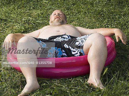 Overweight man in inflatable wading pool