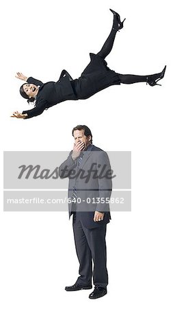 Businesswoman falling on yawning businessman