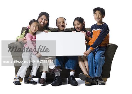 Porträt einer Familie eine leere Schild und Lächeln