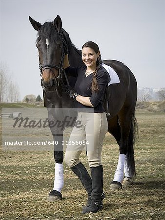 Portrait d'une femme adulte moyenne permanent avec un cheval