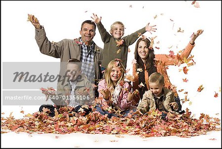 Family posing in a pile of fallen leaves