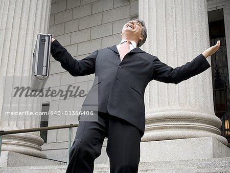 Low Angle View of männlichen Anwalt hält eine Aktentasche und lachen