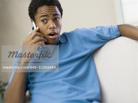 Teenage boy on a mobile phone with his mouth open