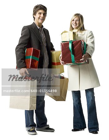 Portrait d'un jeune couple tenant cadeaux et sacs de shopping