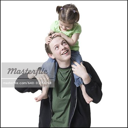 Close-up of a brother carrying his sister on his shoulders