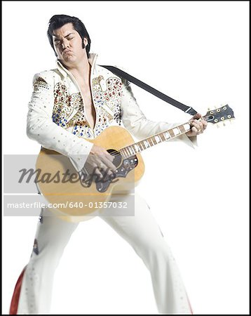 An Elvis impersonator playing the guitar