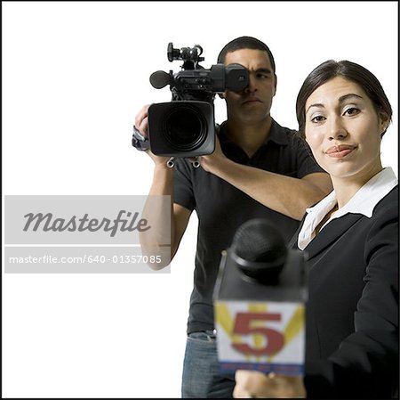 Journaliste avec microphone et vidéaste mâle