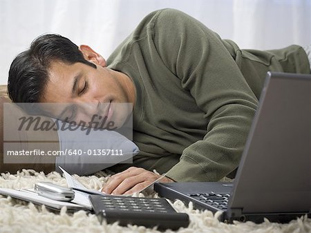 Gros plan d'un homme qui dort à côté de son ordinateur portable