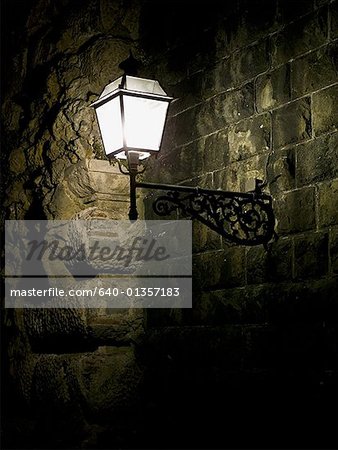 Carriage lamp on brick wall at night