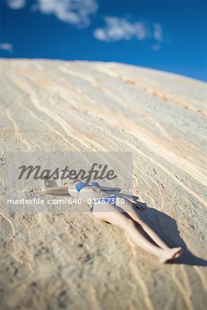 Vue grand angle d'une jeune femme au soleil sur un rocher
