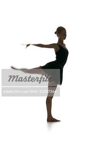 Silhouette of a female ballerina standing on one leg