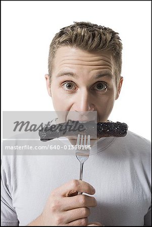 Portrait d'un jeune homme, manger une saucisse