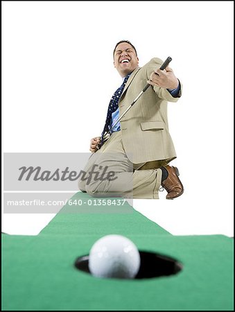 Businessman playing golf on artificial turf