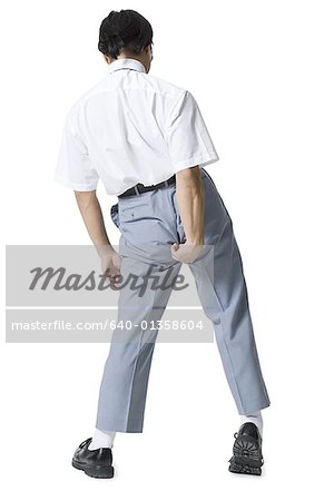 Rear view of a young man adjusting his pants