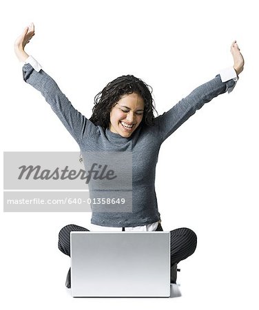 Woman sitting cross legged with laptop stretching