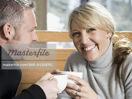 Close-up of an adult couple drinking hot beverages