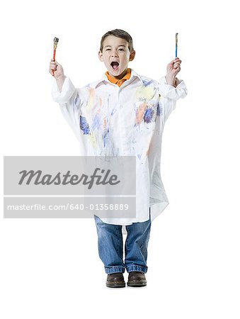 Portrait of a boy holding two paintbrushes