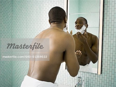 Rear view of a man applying shaving cream