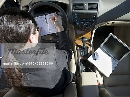 High angle view of a businesswoman working in her car