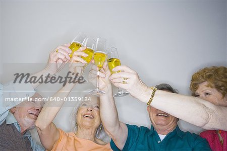 Vue d'angle faible de deux couples âgés faire un toast