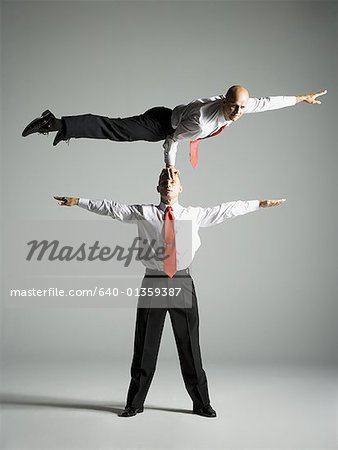 Two male acrobats in business suits