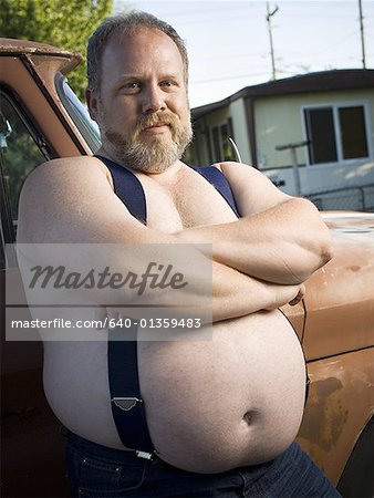 Overweight man with suspenders by truck